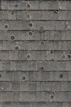 Hail dents on roof shingles.